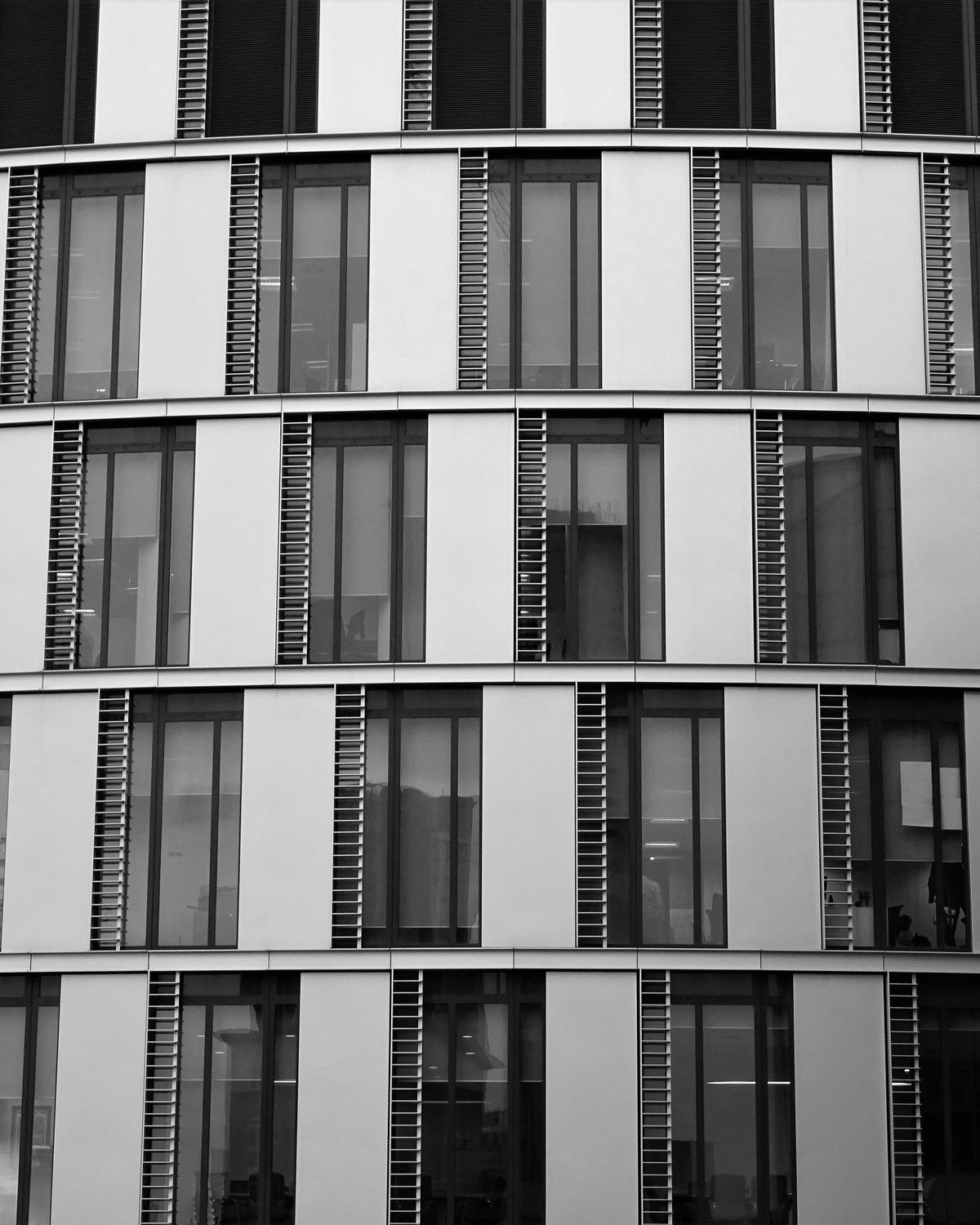 Curved modern office building facade with banded windows