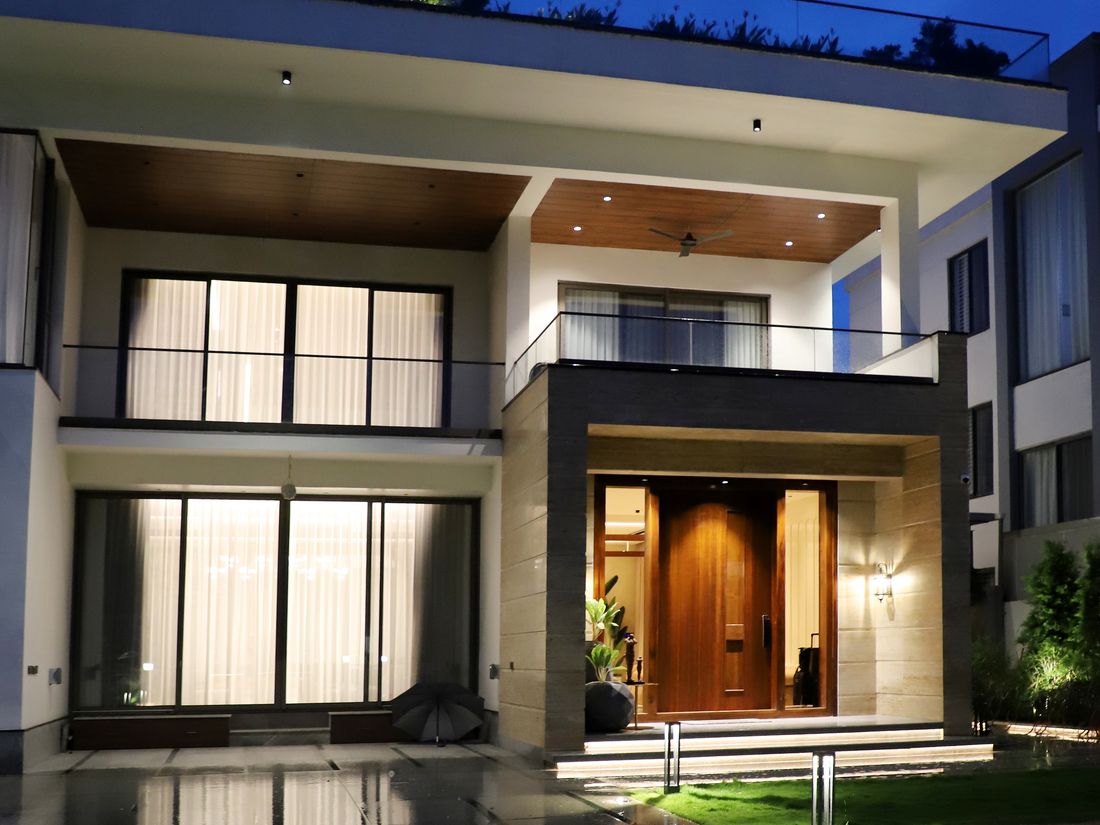 Modern two-storey home with warm interior lighting at blue hour
