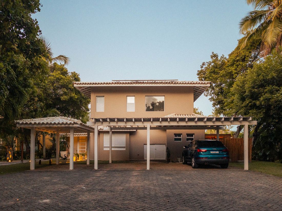 Modern home with carport and palm trees at sunset