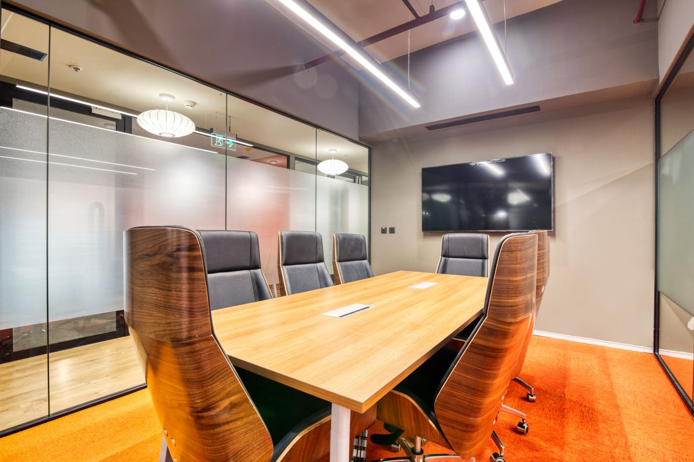 Modern boardroom with glass partitions and recessed lighting