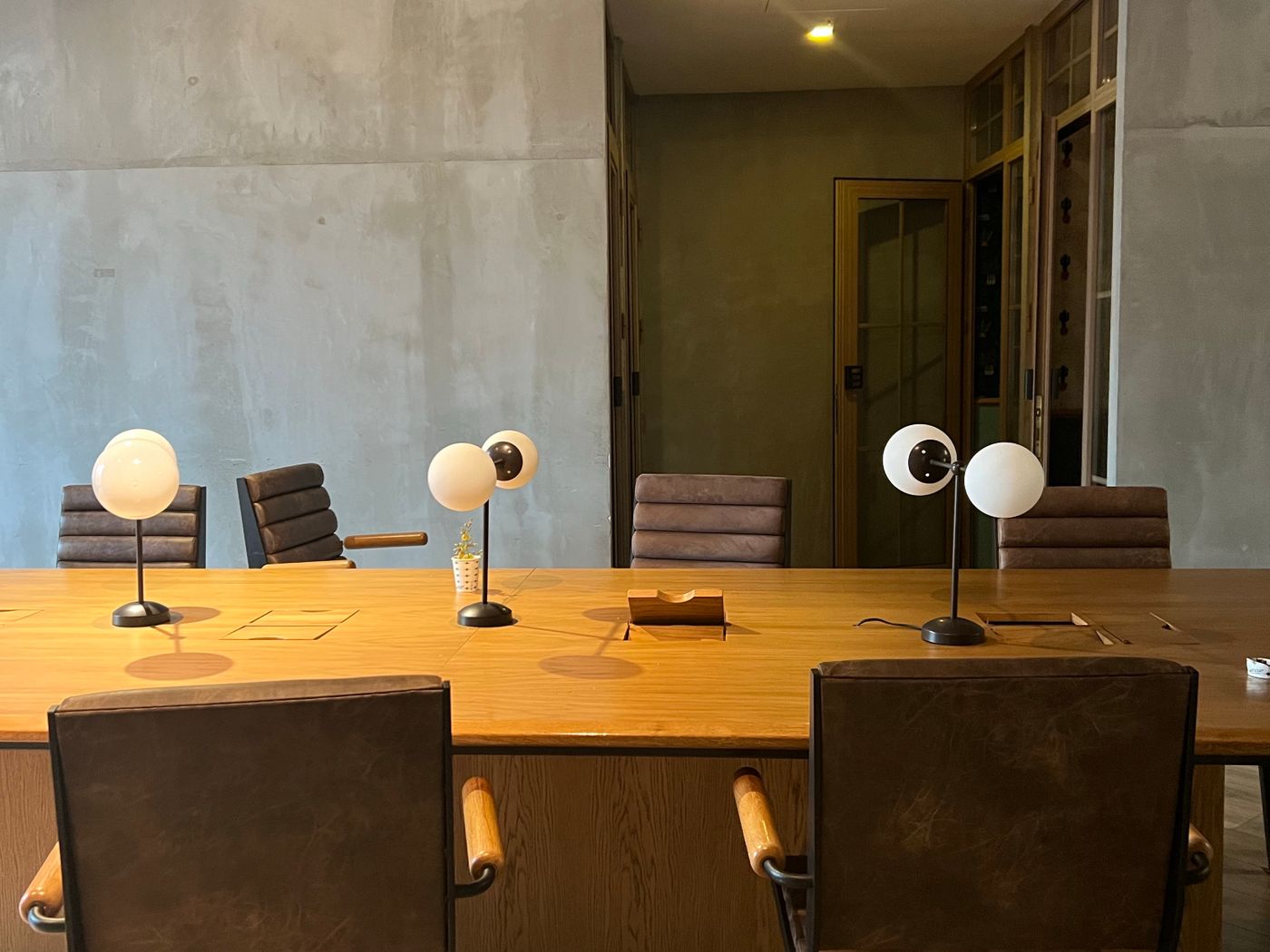 Meeting room with polished concrete walls and warm timber table