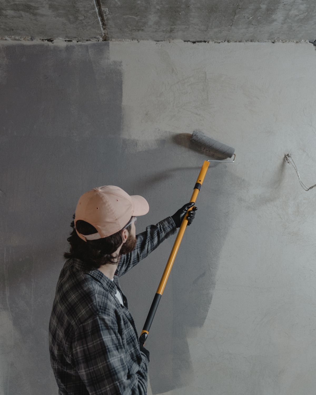 Painter applying a roller coat to a prepared concrete wall