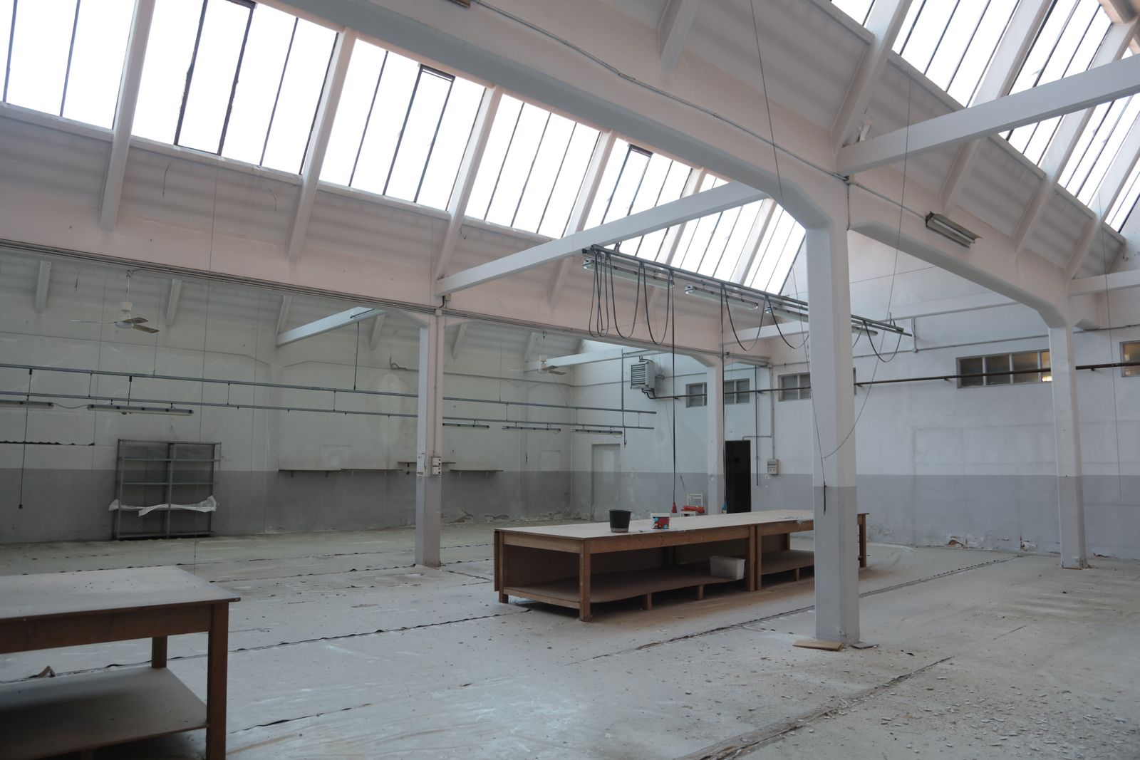 Spacious empty warehouse with freshly painted white steel roof structure