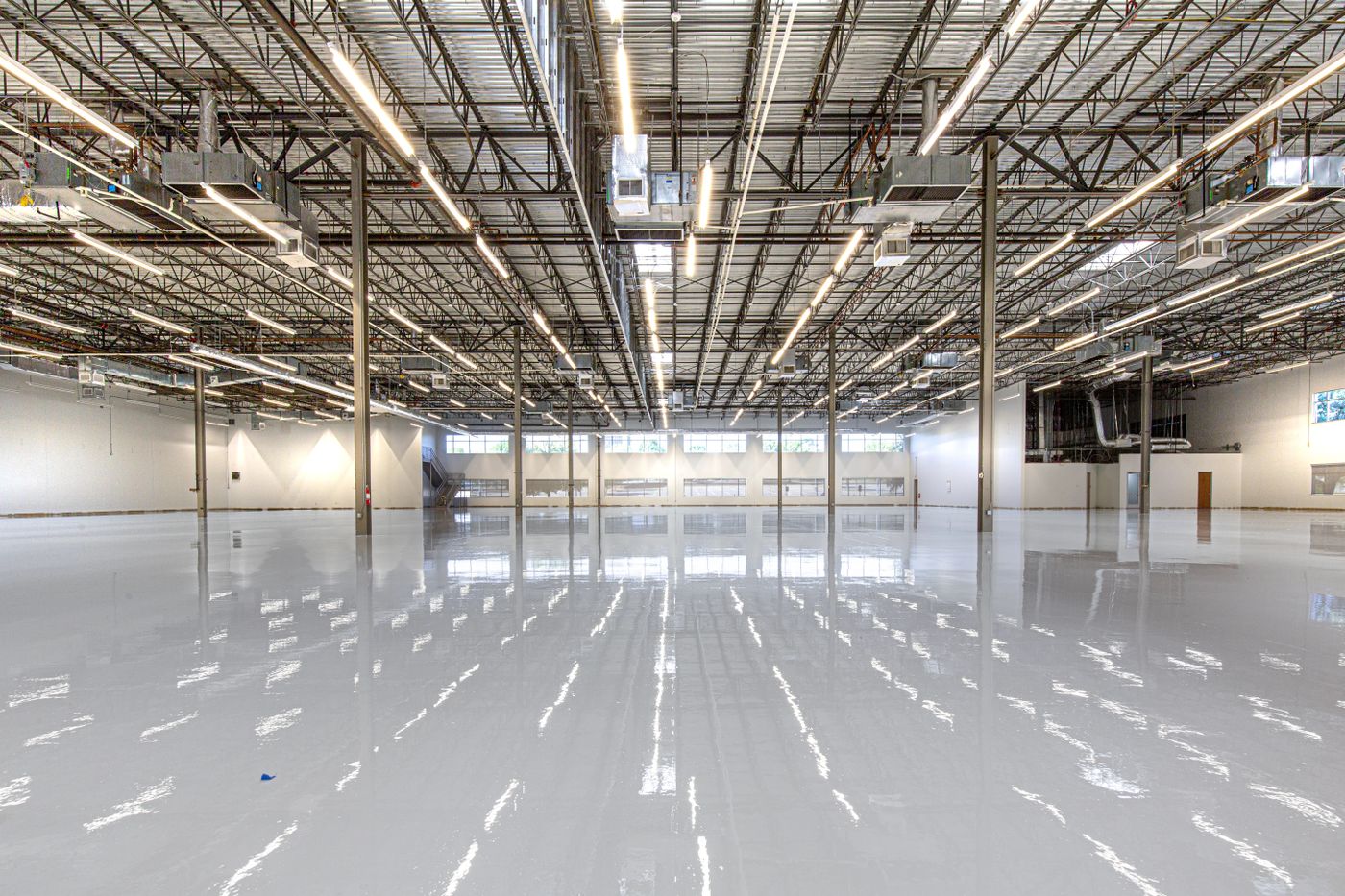 Large seamless epoxy floor coating reflecting overhead lighting